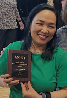 Janice Chase holding an NHTI award plaque